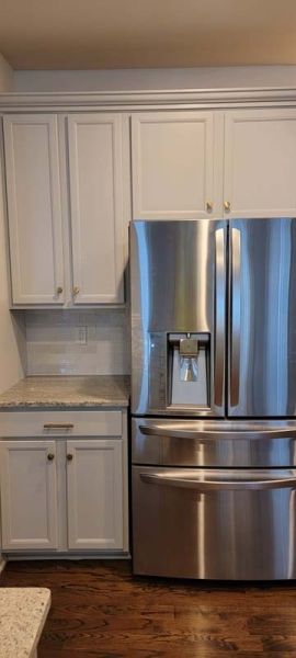 Remodeled kitchen with stainless steel fridge.